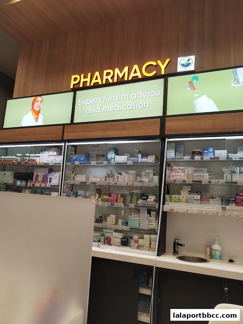 A well-lit pharmacy interior with shelves stocked with various medications and health products.