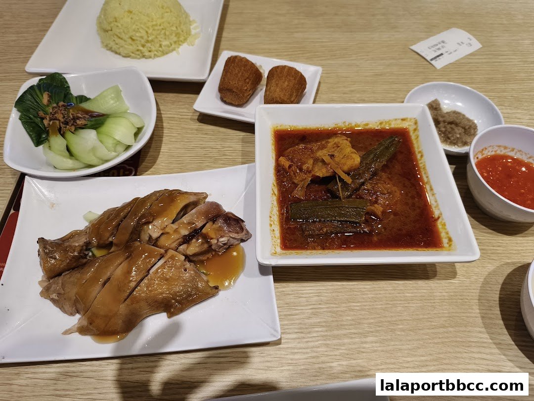 A table laden with delicious Malaysian chicken rice and curry dishes.