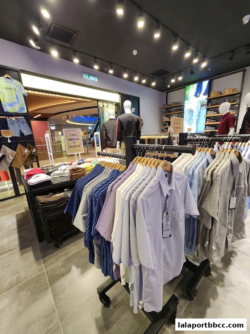 Interior view of a clothing store with racks of men's shirts and display mannequins.