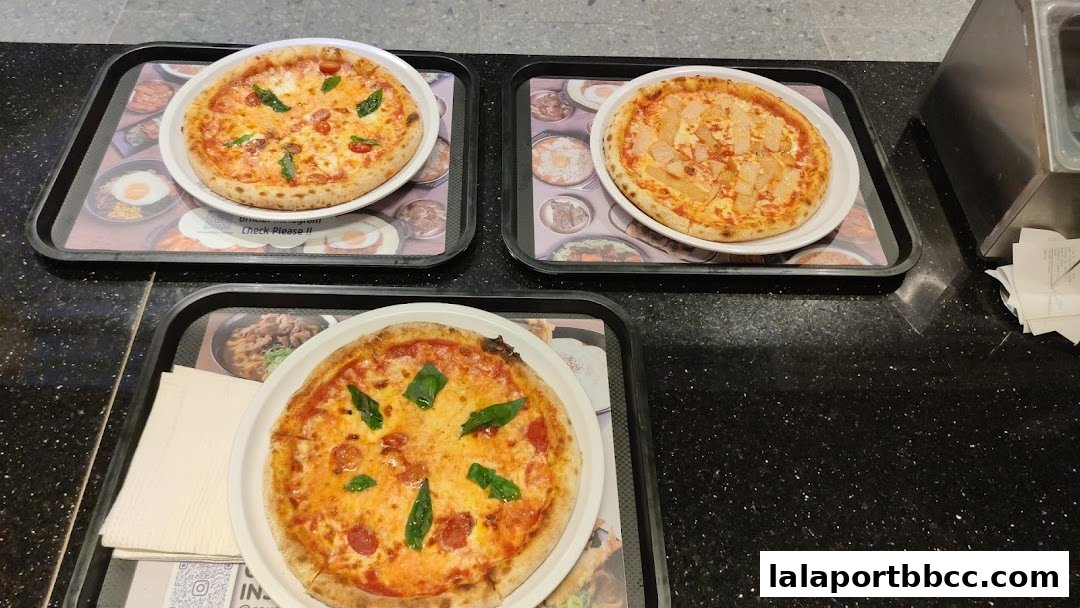 Three pizzas are displayed on trays, ready to be served.