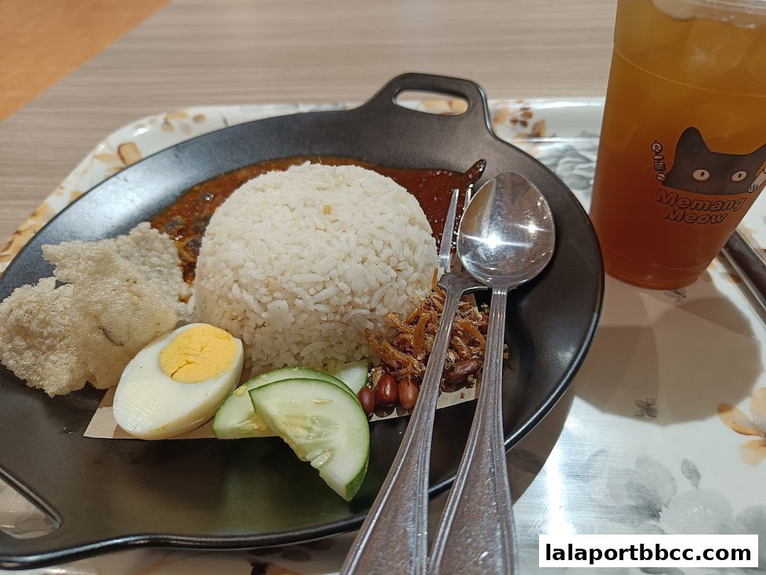 A plate of Nasi Lemak with a side of iced tea from Memang Meow.