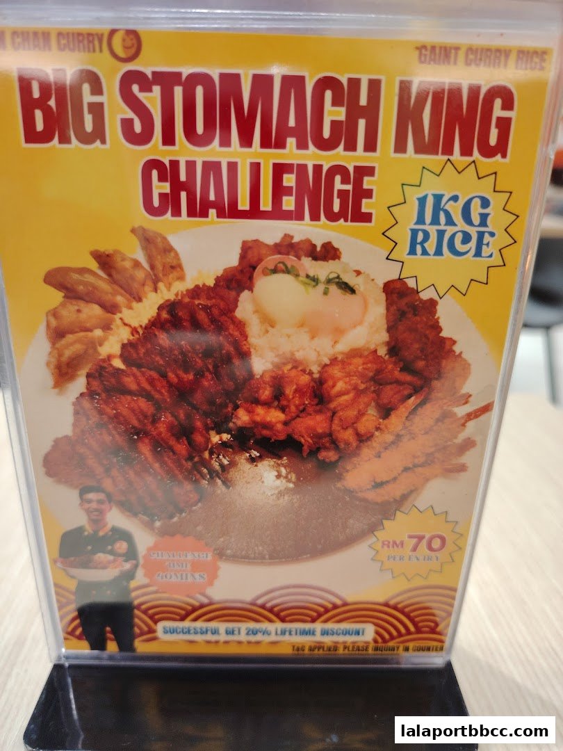 A promotional sign for Ken-Chan Curry's 'Big Stomach King Challenge' featuring a large meal.