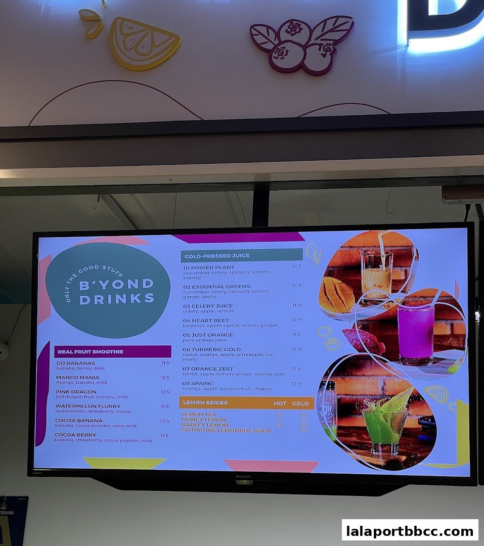 A digital menu board displaying a variety of cold-pressed juices and smoothies with prices.