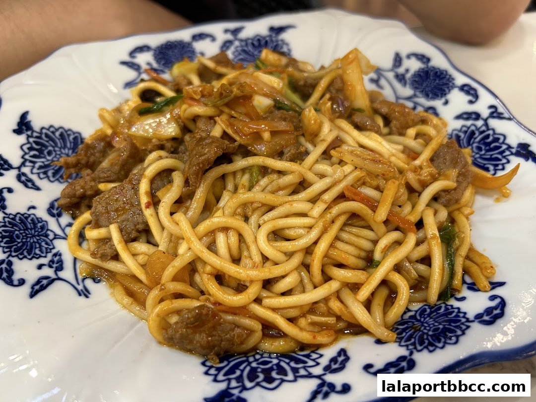 A close-up of a delicious plate of stir-fried noodles with beef and vegetables.