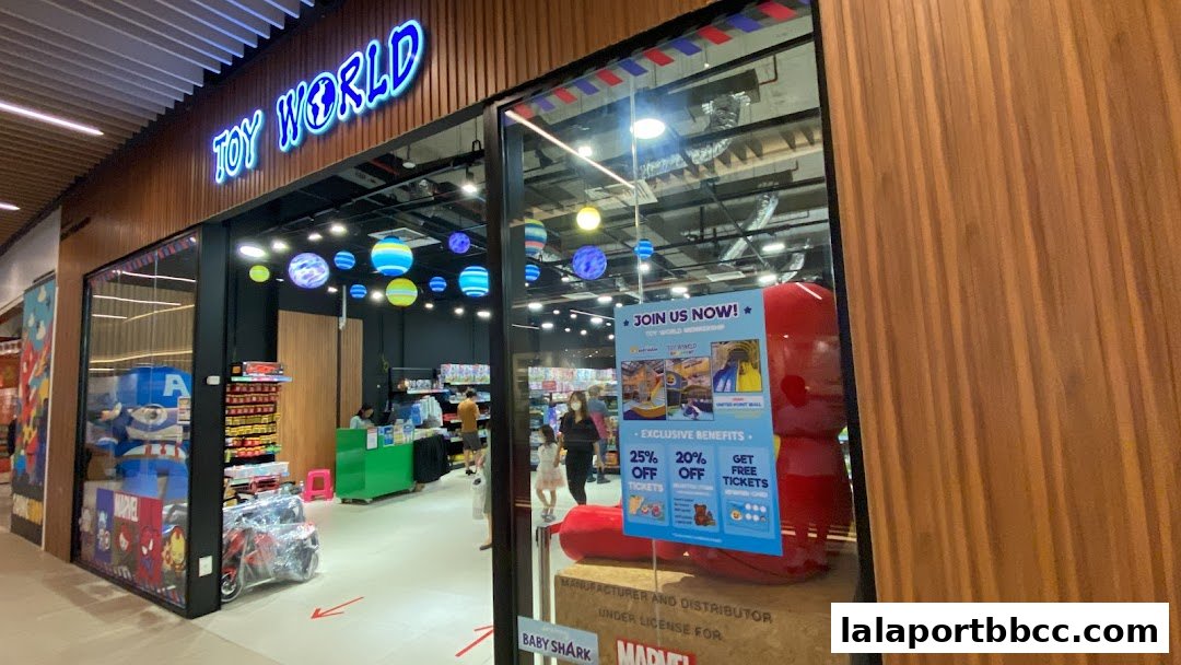 The entrance of Toy World, a brightly lit toy store with colorful displays and a large red inflatable figure.