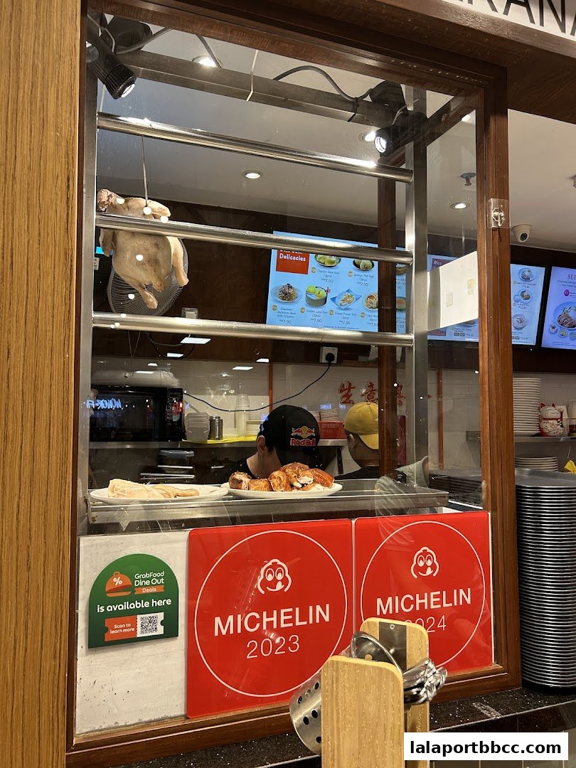 A view into a restaurant kitchen showing hanging chicken and Michelin awards.