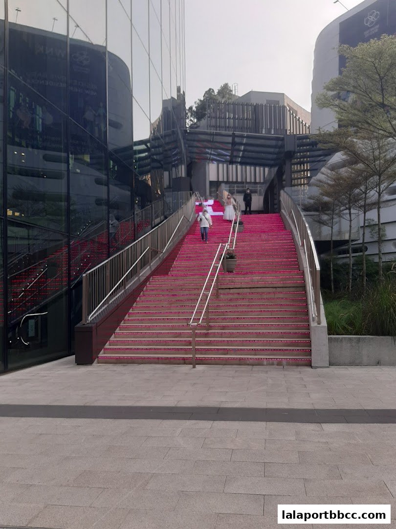 People walking up illuminated pink stairs at The Grand Steps at Lalaport BBCC.
