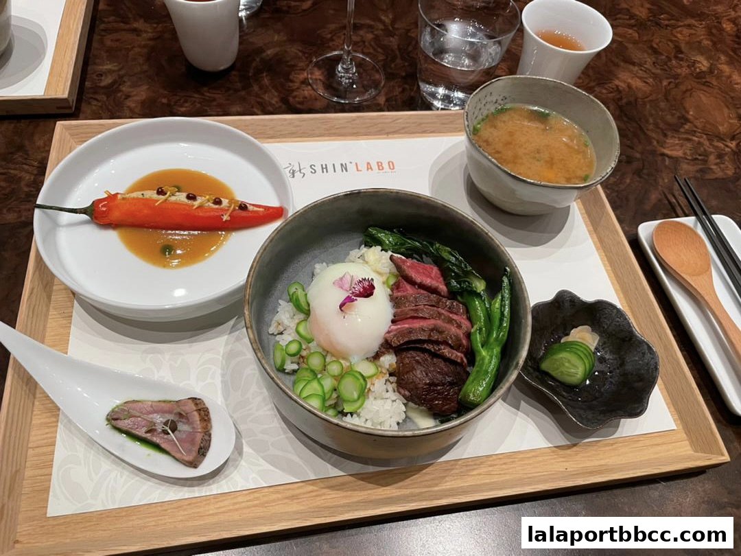 A beautifully presented meal with steak, rice, vegetables, soup, and a stuffed pepper.
