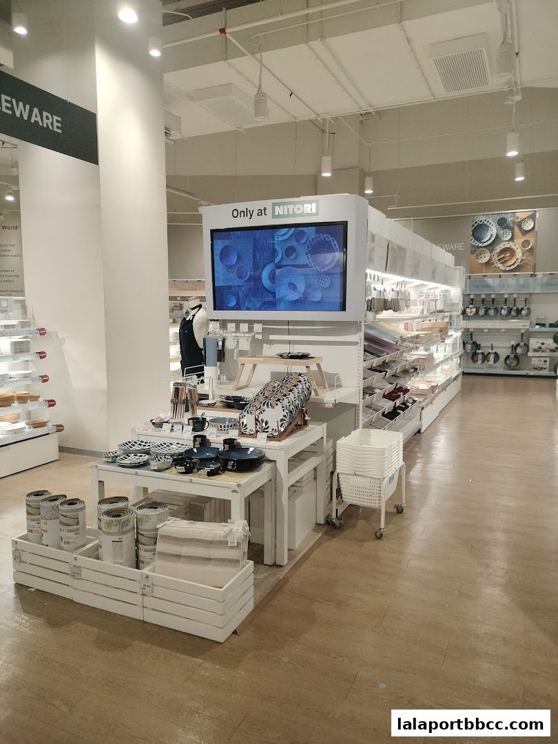 Interior view of a NITORI store showcasing tableware, kitchenware, and home decor items.