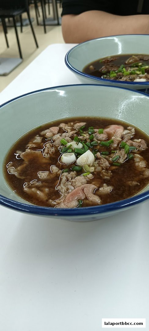 Two bowls of steaming Hong Kong-style noodles with beef and green onions.