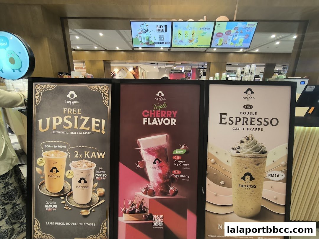 Three large posters advertising drinks from Hercaa, featuring Thai tea, cherry flavor, and espresso frappe.