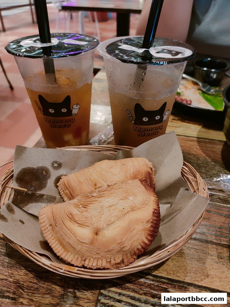 Two bubble teas and two pastries served in a basket at Memang Meow.
