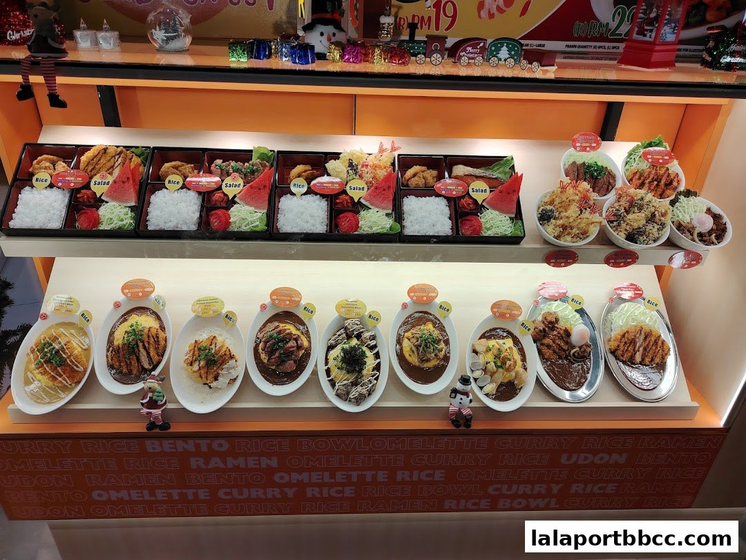 A display case filled with various Japanese food items, including bento boxes and curry rice.