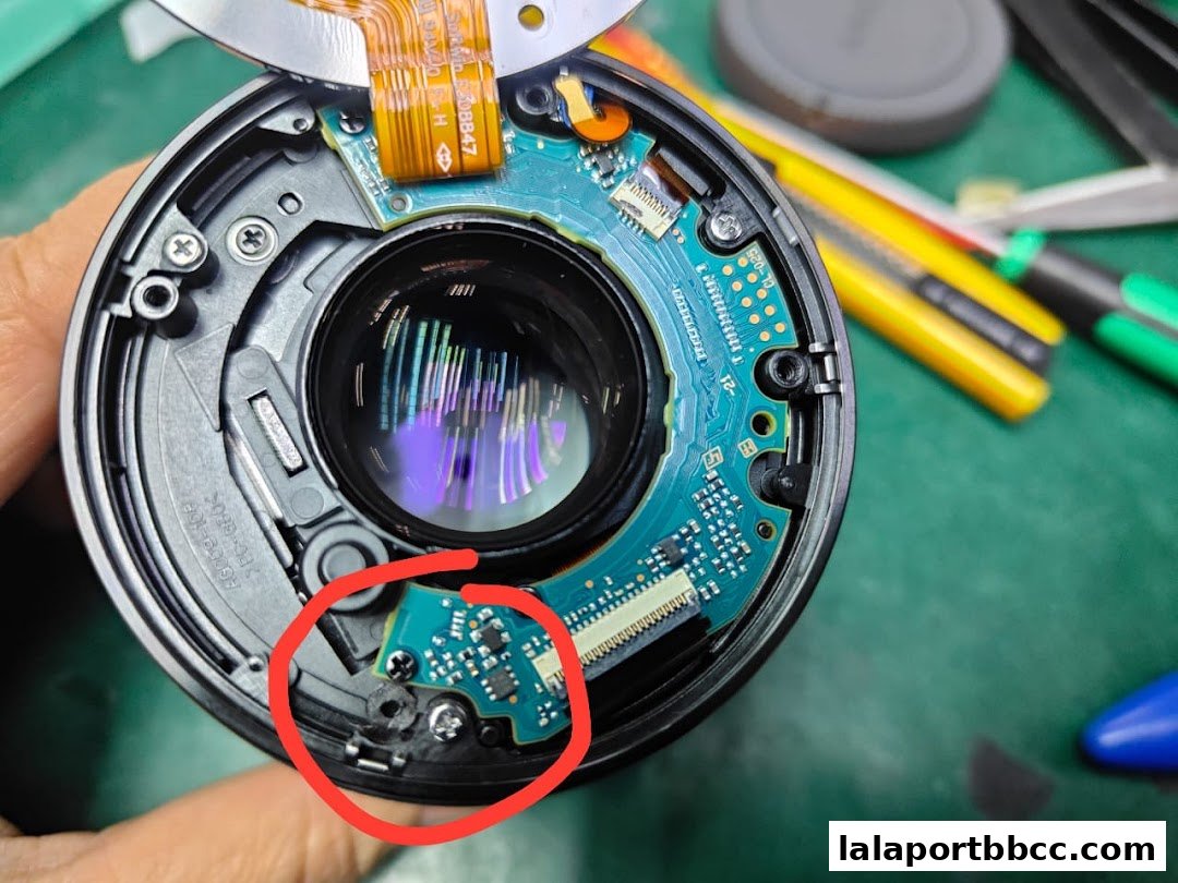 Close-up of a disassembled camera lens showing internal electronics and circuitry.