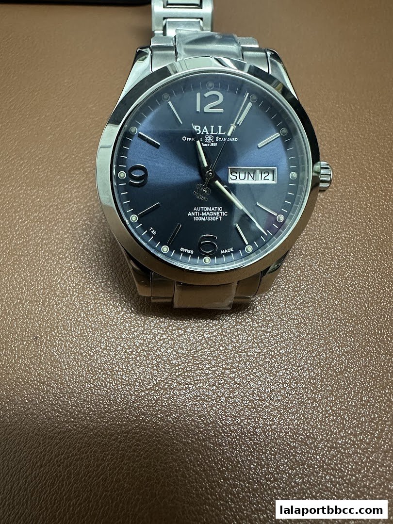A close-up shot of a BALL brand automatic wristwatch with a blue dial.