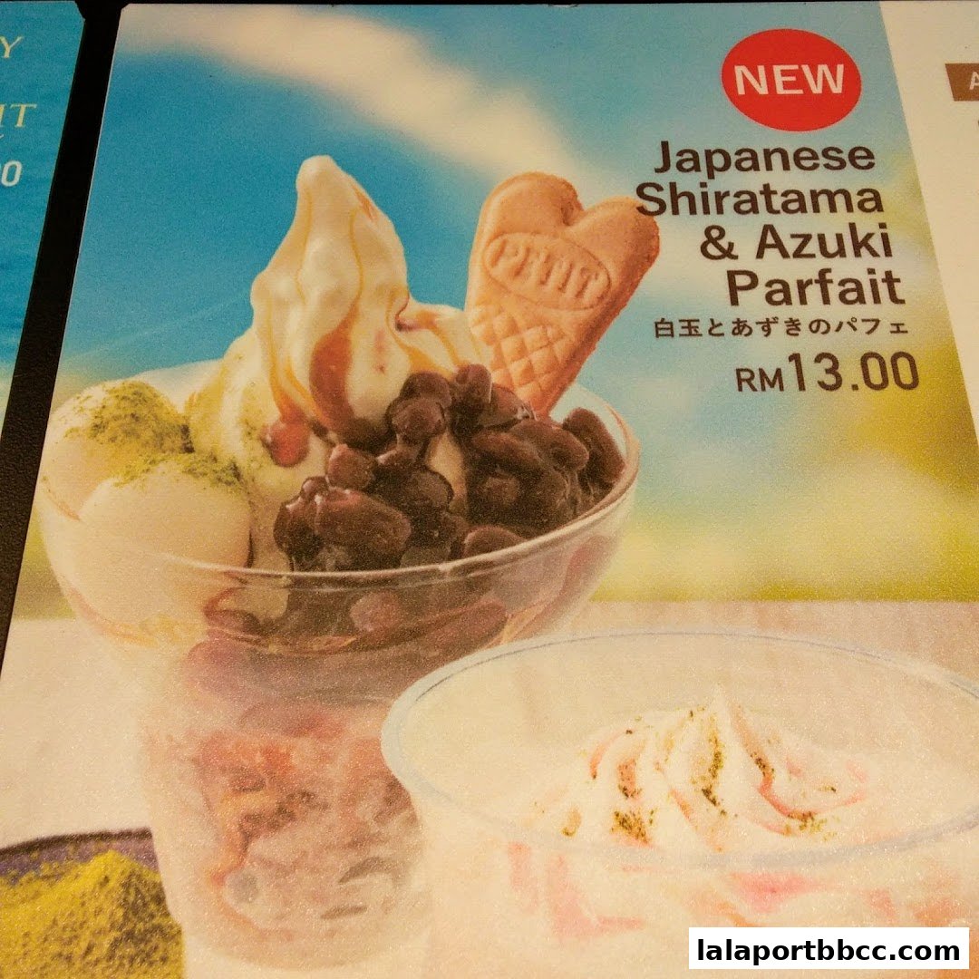A close-up of a Japanese Shiratama & Azuki Parfait with ice cream, red beans, and a heart-shaped cookie.