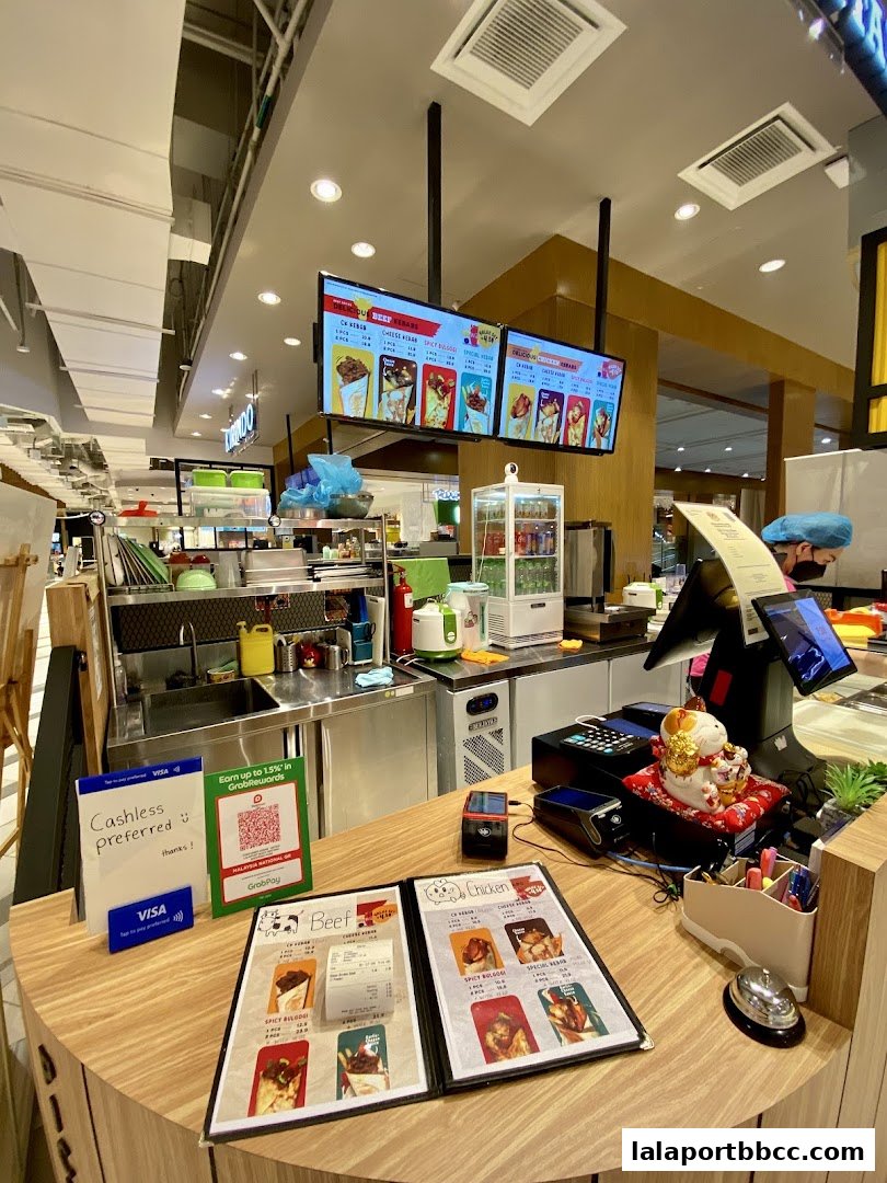 A counter at Container Kebab with menus, payment terminals, and a lucky cat.
