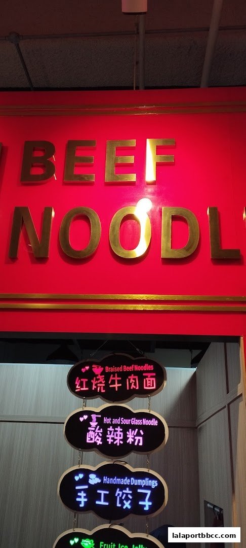 A food stall sign displaying various noodle and dumpling dishes with Chinese and English text.