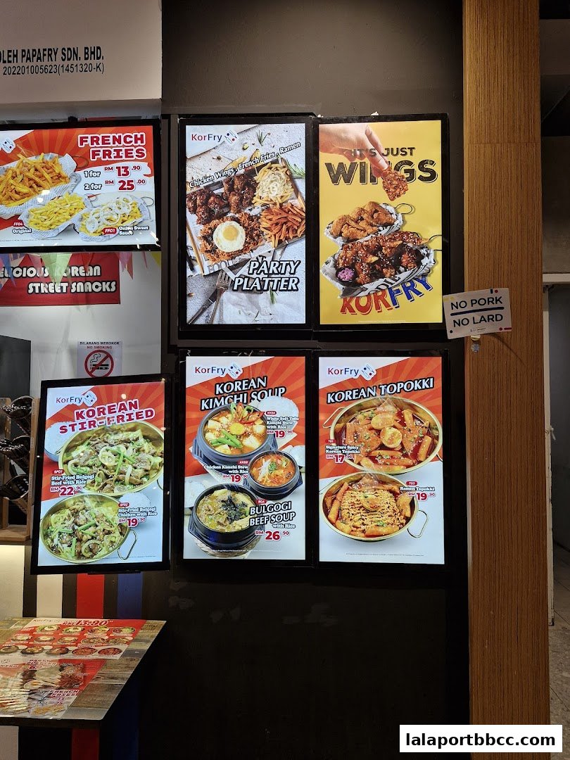 A display of illuminated menu boards showcasing Korean street food and fried chicken.