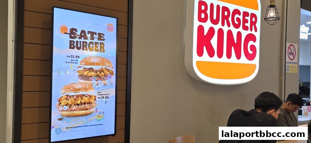 Burger King's illuminated sign and a digital menu board showcasing Sate Burgers.