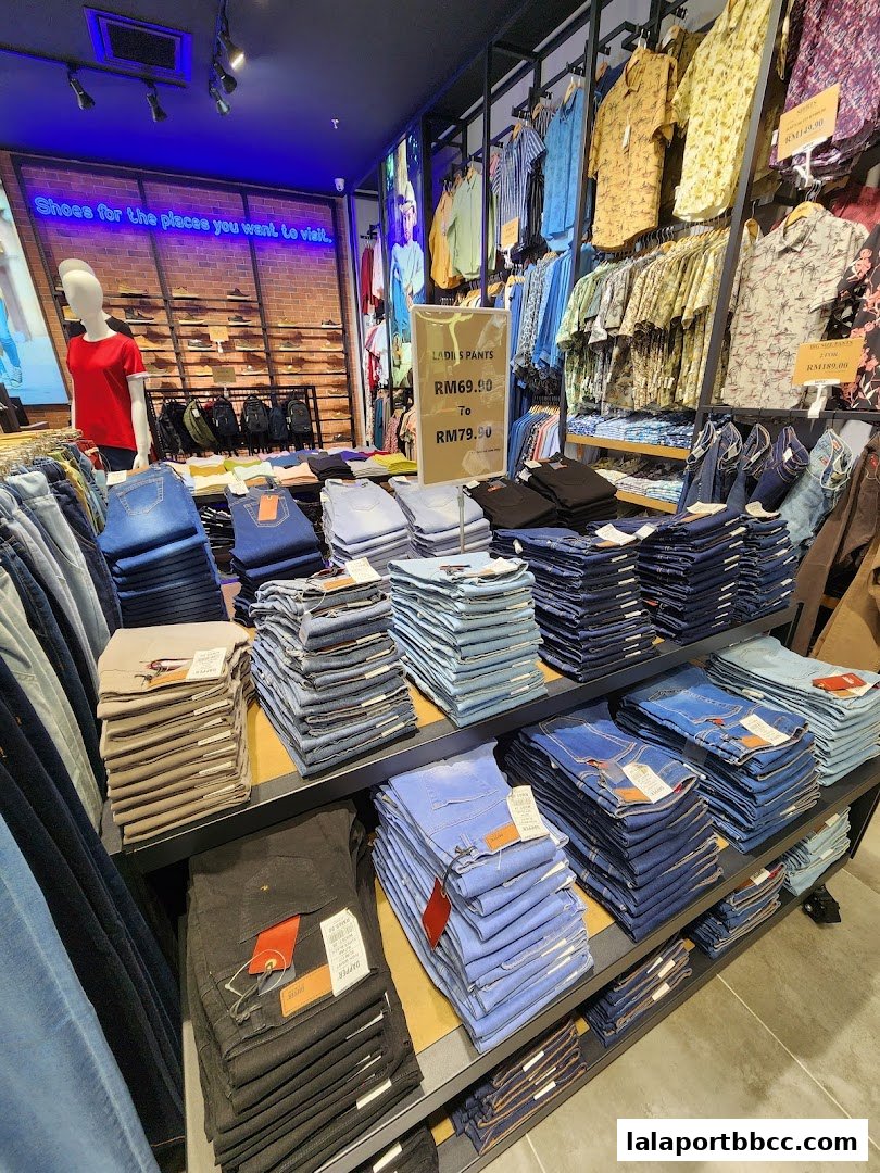 A well-organized display of folded jeans and shirts in a retail store.