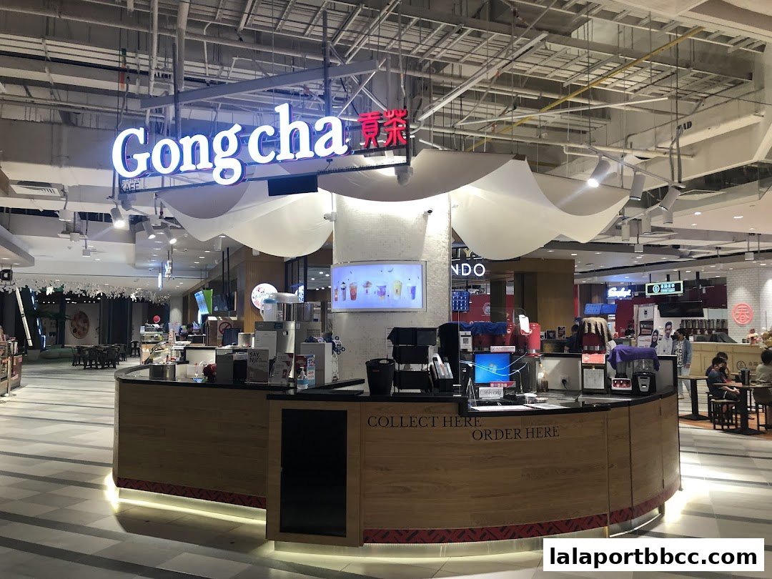 A Gong Cha bubble tea shop counter with staff and customers in a mall.