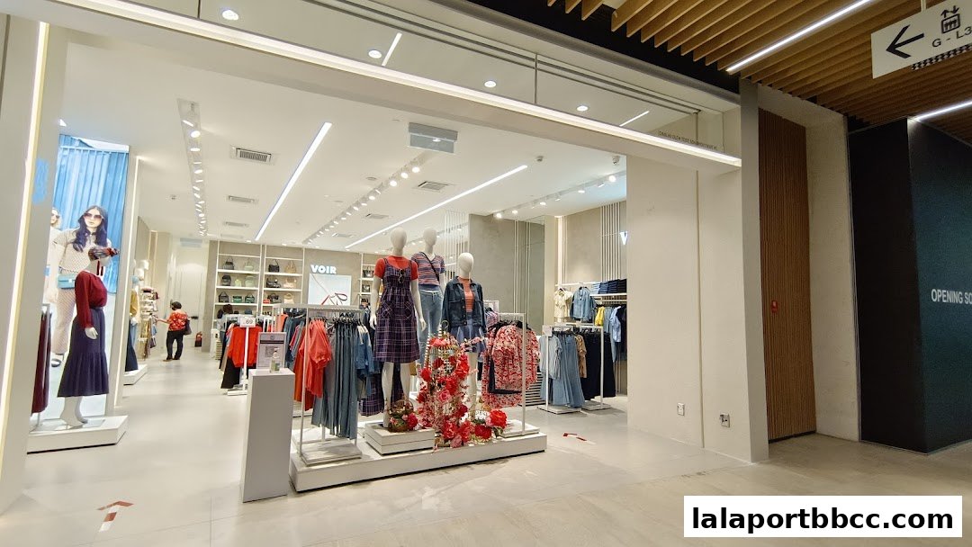 Interior view of a clothing store with mannequins displaying outfits and racks of apparel.