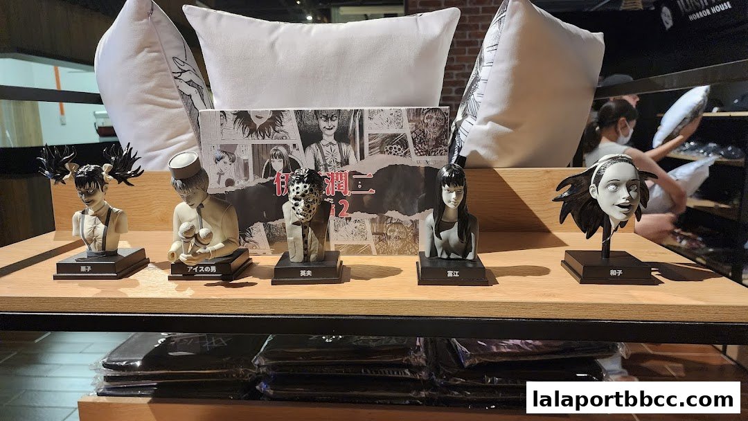 Junji Ito Horror House merchandise display featuring character busts and pillows.
