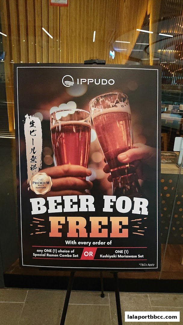 A promotional sign for Ippudo offering free beer with select meal combos.