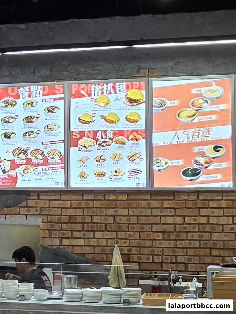 A brightly lit menu board displaying various dessert and snack options with appealing food photography.
