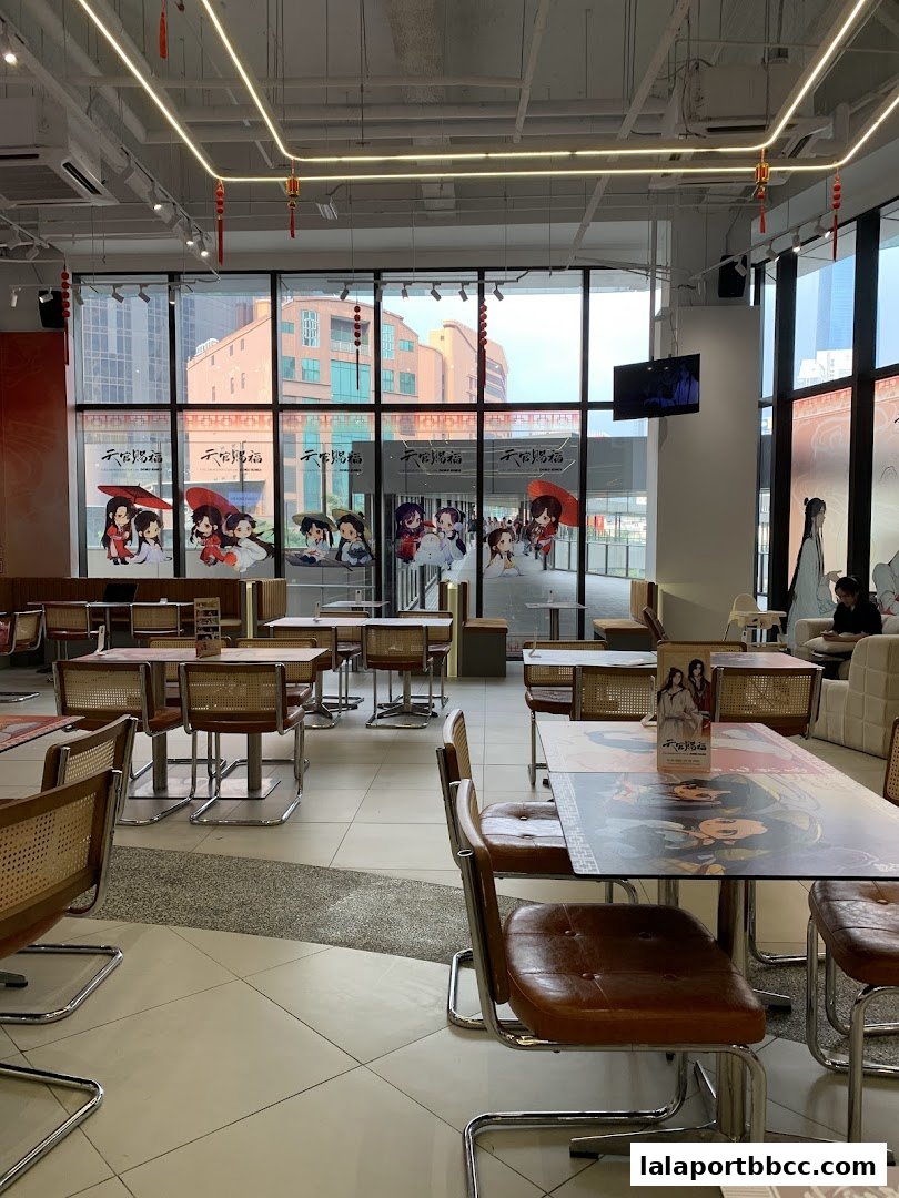 Interior of a cafe with tables, chairs, and anime-themed decorations.