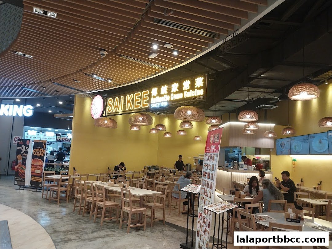 Interior view of Sai Kee Restaurant with tables, chairs, and customers dining.