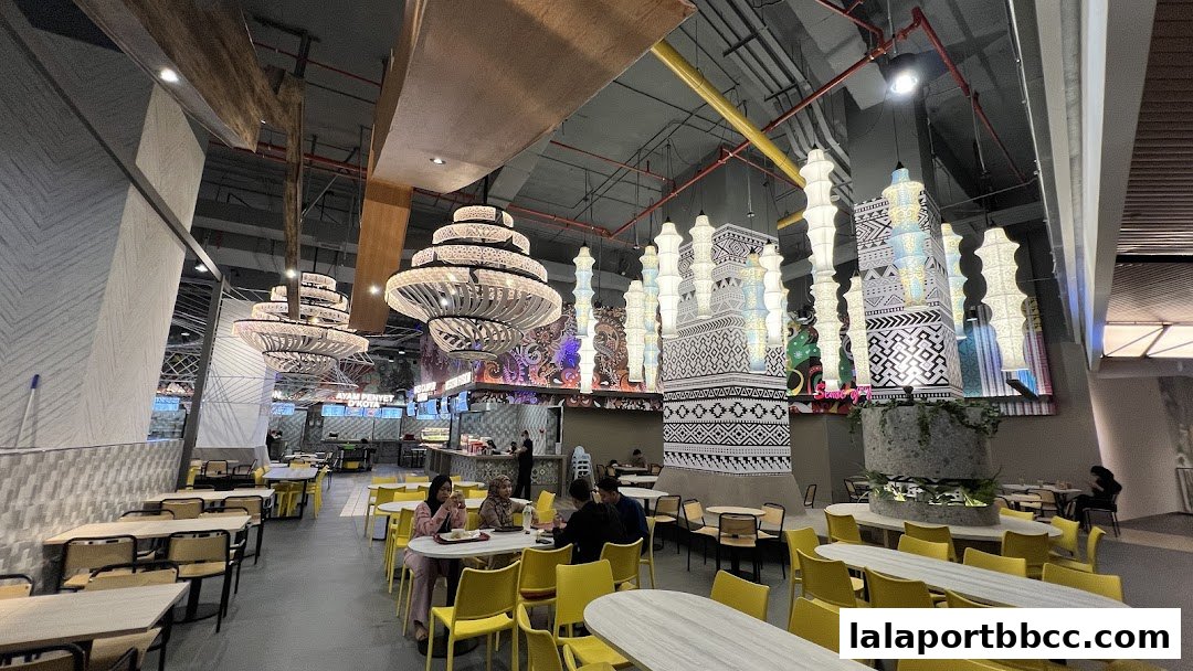 A spacious food court with modern decor, featuring unique lighting fixtures and seating areas.