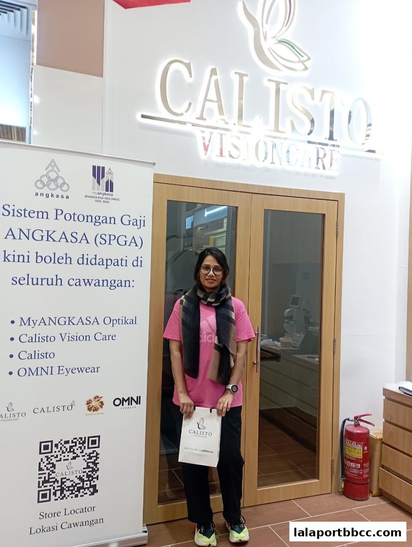 A woman stands in front of the Calisto Vision Care store entrance with a promotional banner.