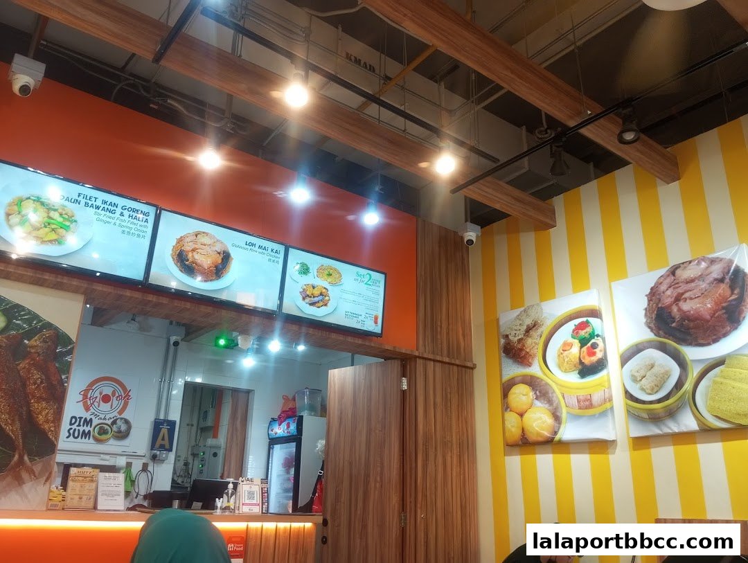 Interior view of a restaurant with digital menus displaying food items and decorative wall art.
