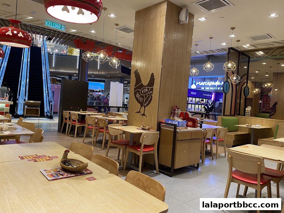 Interior of a brightly lit restaurant with wooden tables and chairs, featuring chicken-themed decor.