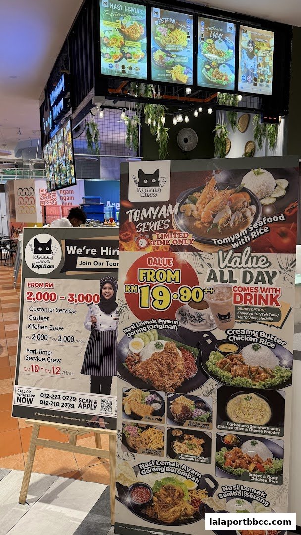 A display board showcasing various Malaysian dishes and job openings for Memang Meow Kopitiam.