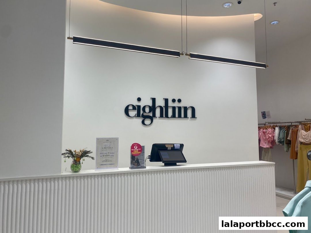 The interior of Eightiin Fashion with a counter, signage, and clothing racks.