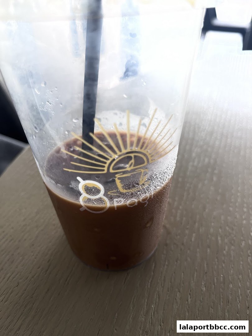 A close-up of a cold coffee drink in a clear plastic cup with condensation.