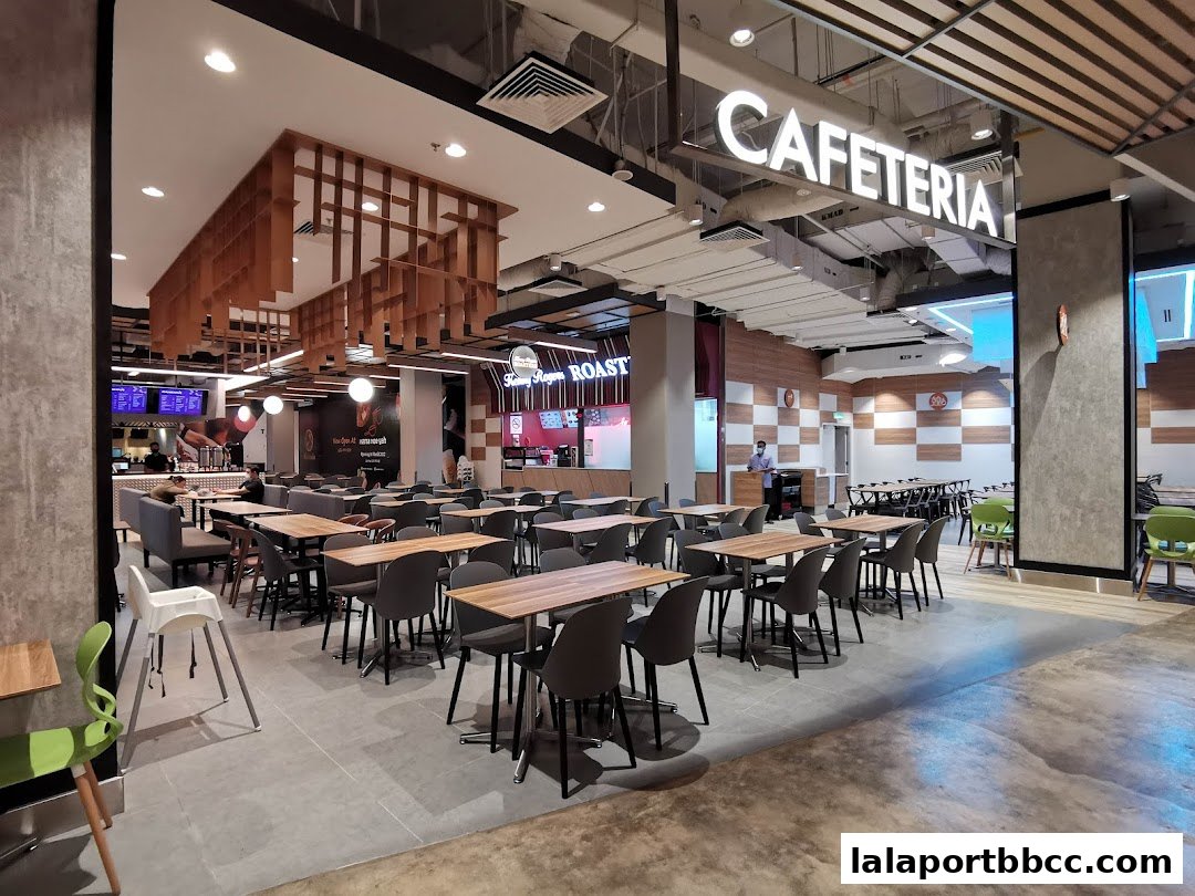 Interior view of a spacious cafeteria with many tables and chairs, and a counter area.