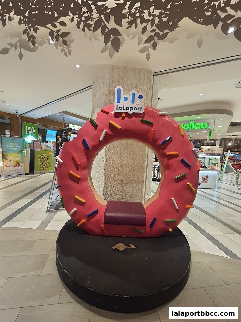 A giant pink donut prop with sprinkles and a seat, branded with Lalaport.