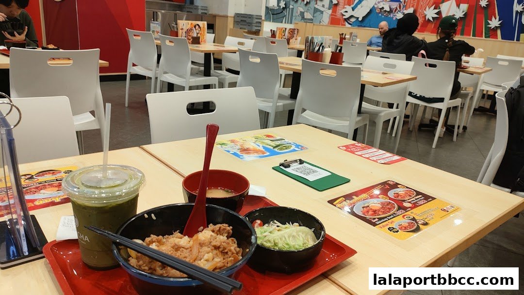 A table at Sukiya Tokyo Bowls & Noodles with food, drinks, and menus.