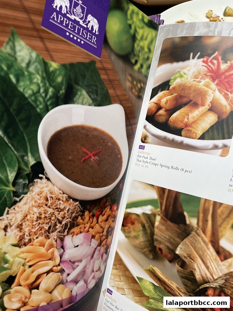 A menu featuring Thai appetizers, including spring rolls and a dish wrapped in leaves.