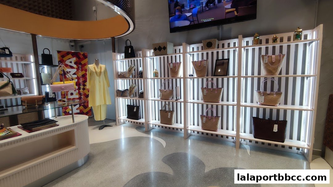 A well-lit retail store interior showcasing handbags and traditional Malaysian attire.