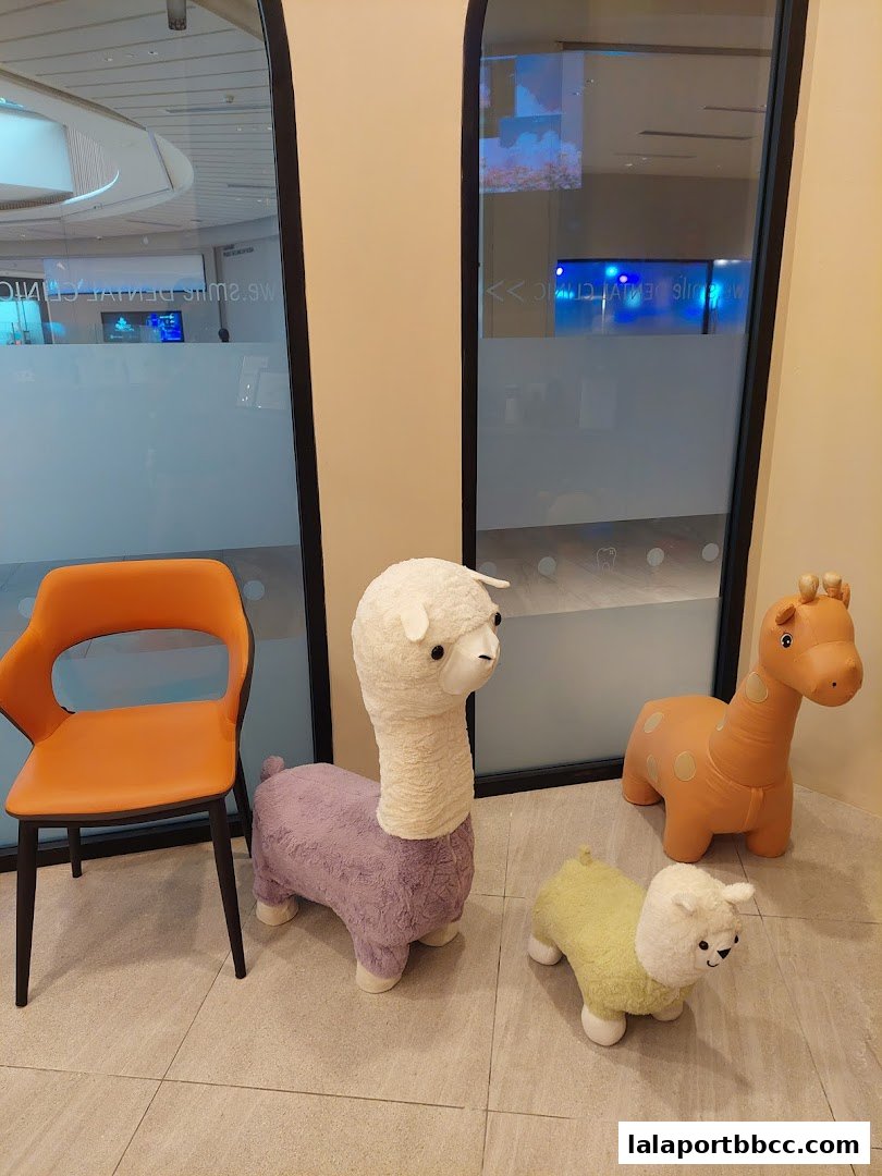 A waiting area with animal-shaped seating and an orange chair at a dental clinic.