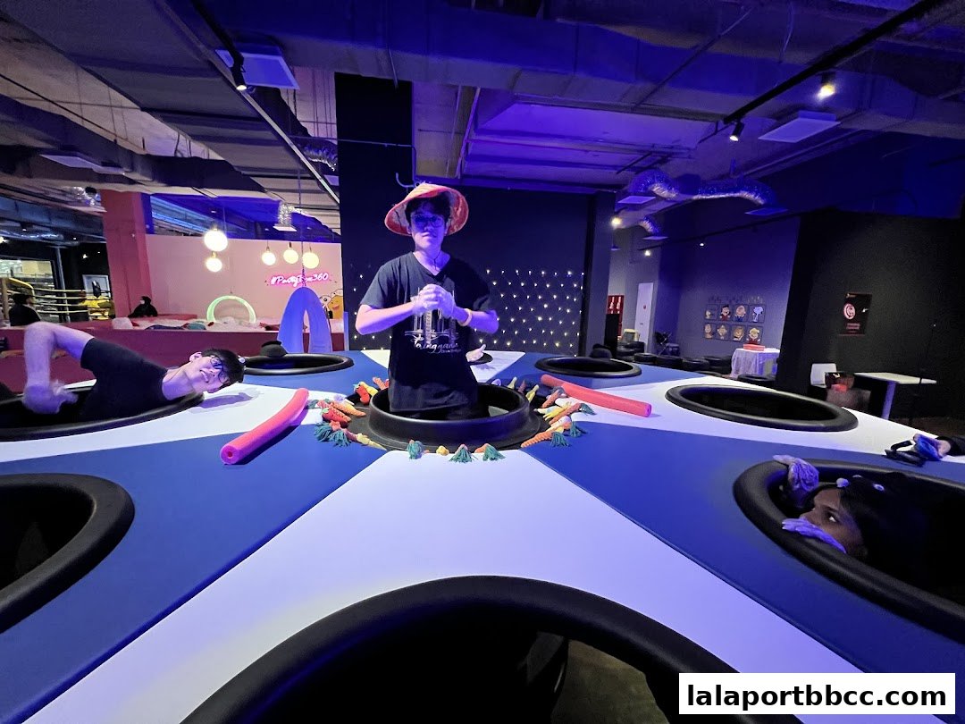 People interacting with a colorful, interactive game at PartyBox 360.