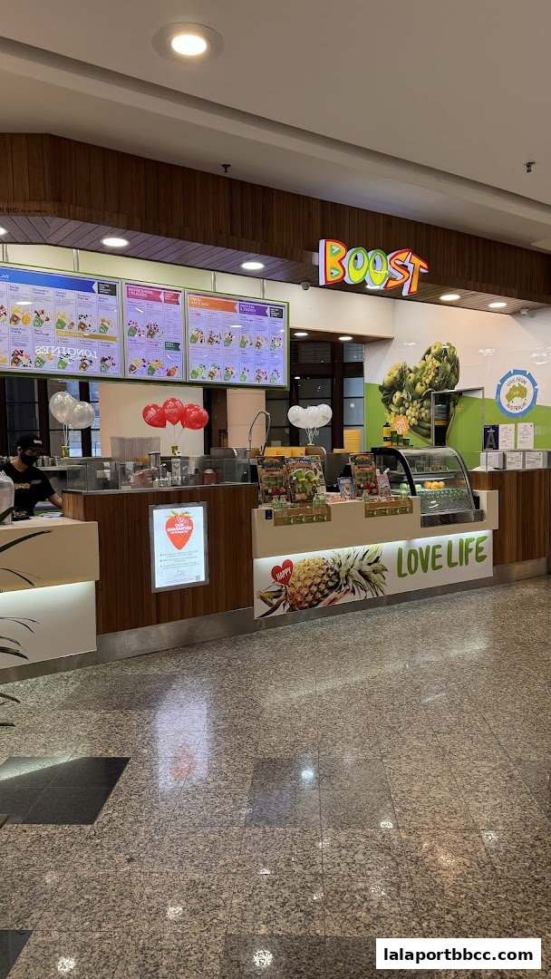 A Boost Juice shop counter with menus, fresh fruits, and promotional materials.