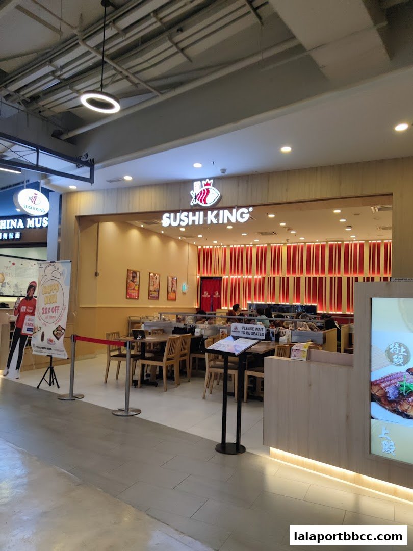 The exterior of a Sushi King restaurant with seating visible inside.