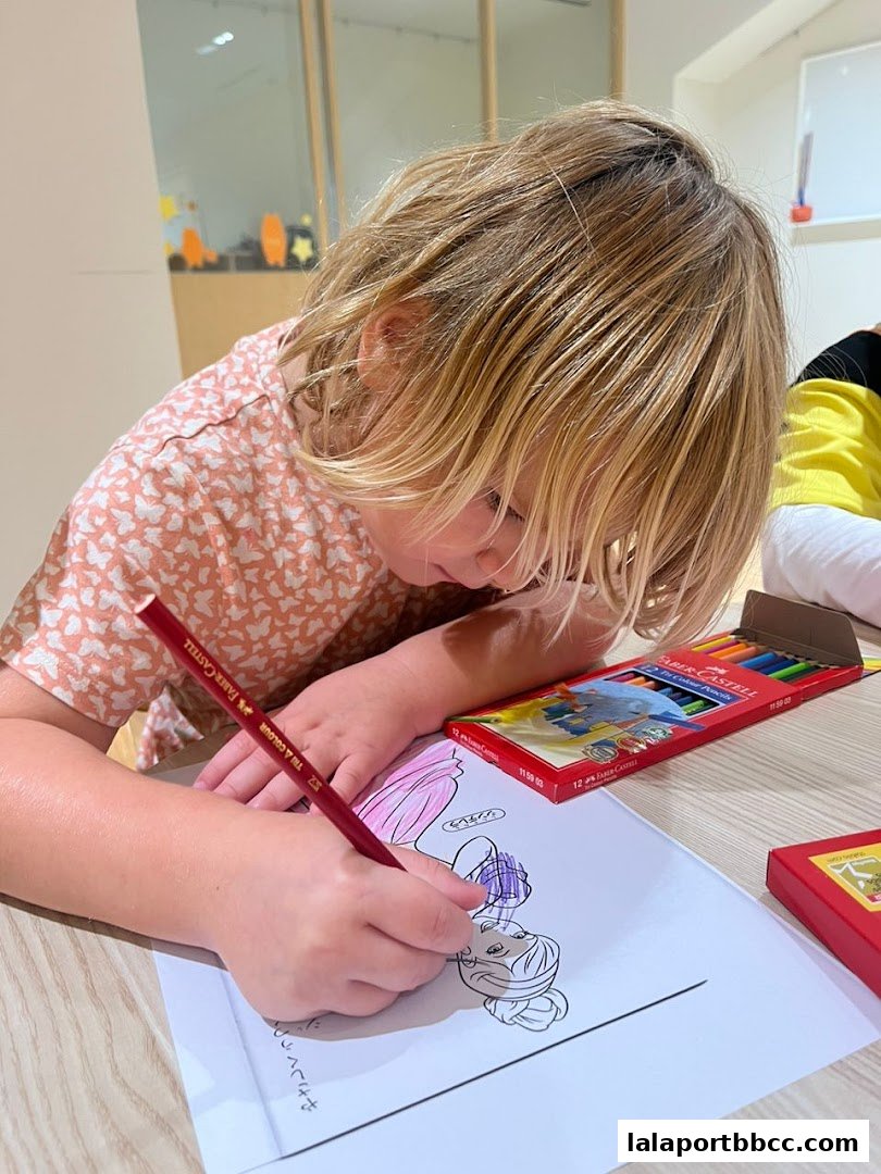 A young child is focused on coloring a drawing with colored pencils.