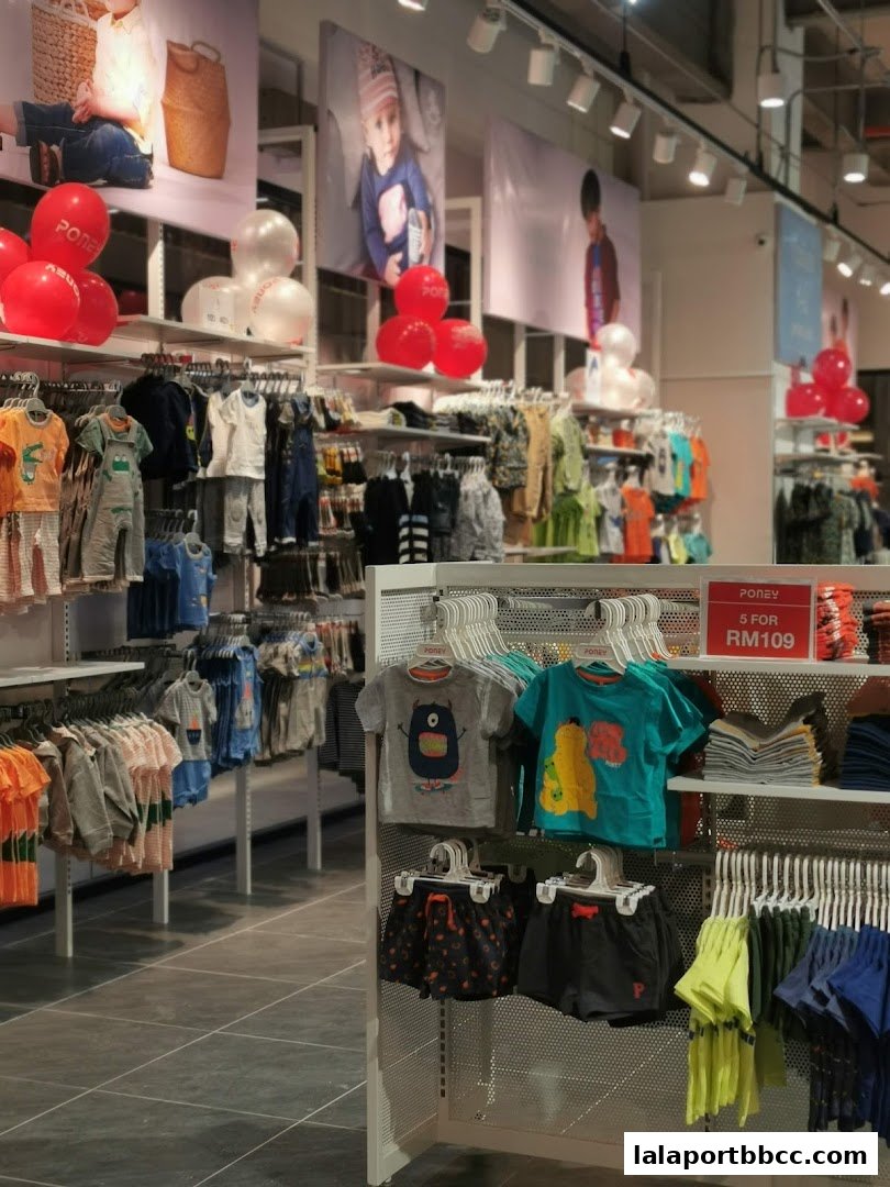 A brightly lit children's clothing store interior with racks of colorful apparel and promotional balloons.